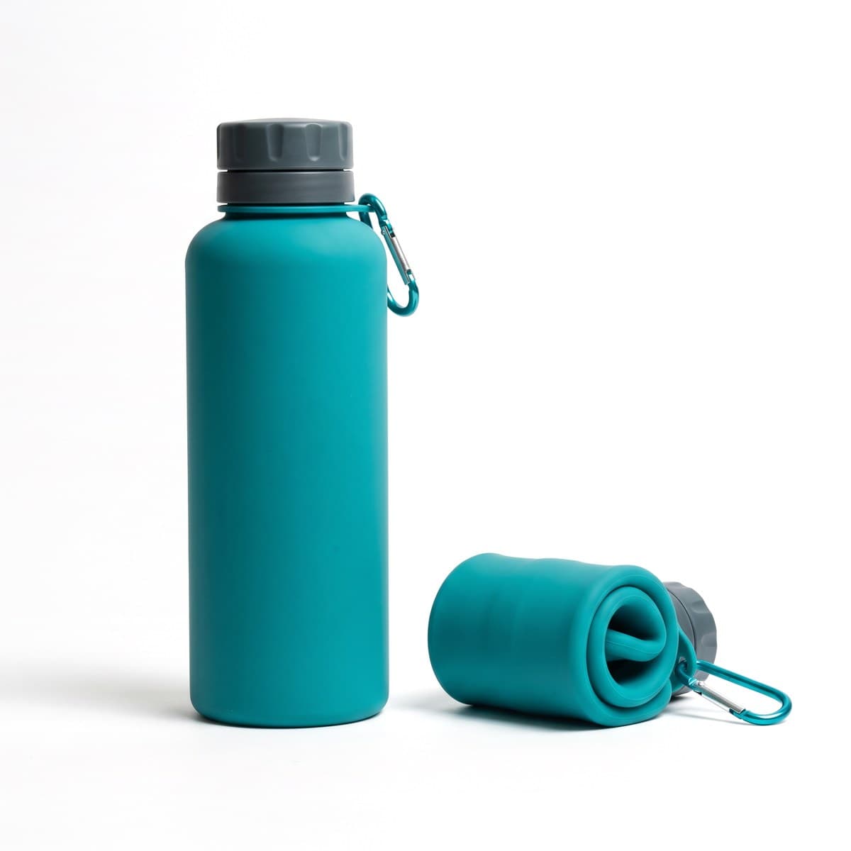 A teal silicone water bottle standing full beside the same bottle rolled flat, a carabiner on the screw cap