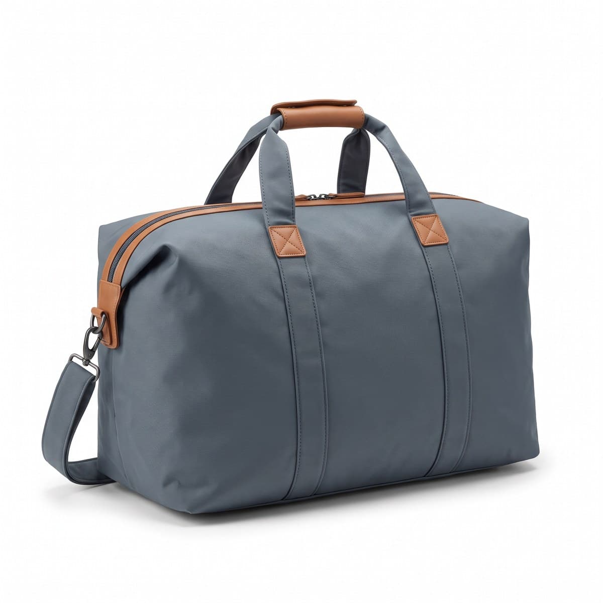 A soft-sided slate weekender bag with tan trim, its wide top zipped shut, grab handles joined by a wrap and a shoulder strap looped beside it